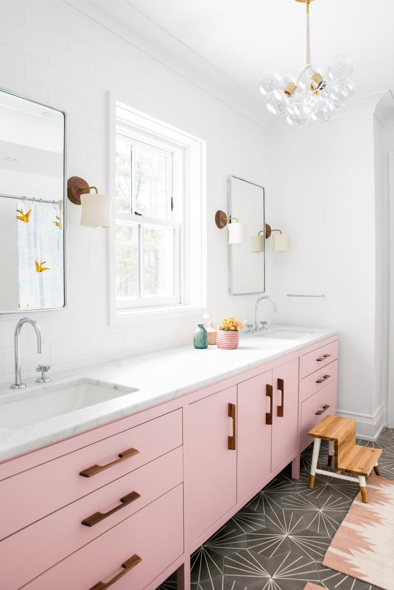 A bathroom with pink cabinetry