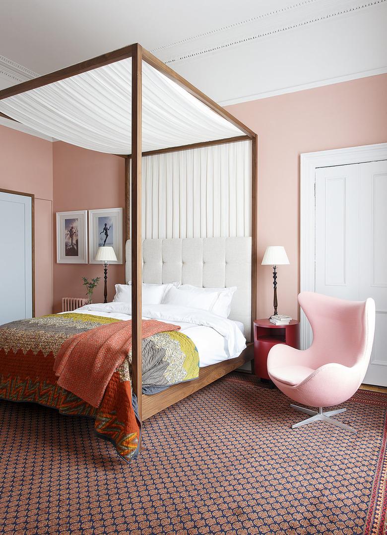 pale pink bedroom with four-poster canopy bed and Egg chair