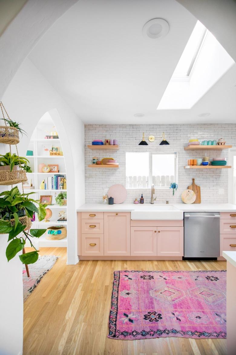 white kitchen with pink cabinets and hot pink rug