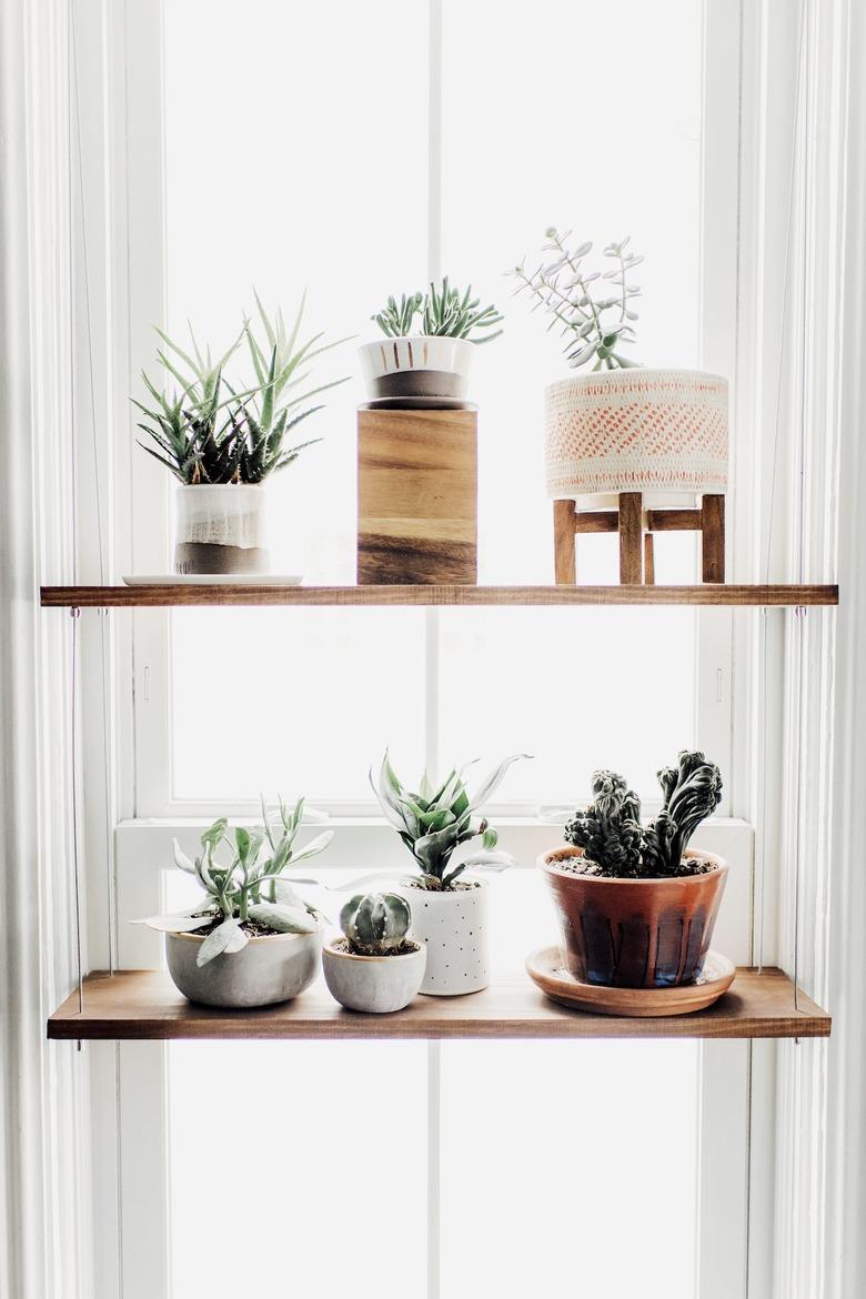 kitchen window idea with hanging shelf with wooden planks and assorted ceramic pots