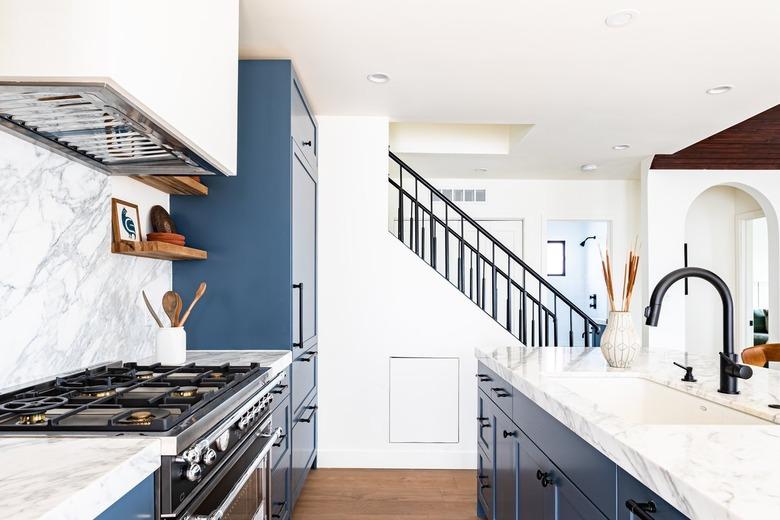 kitchen range between blue cabinets and marble countertops