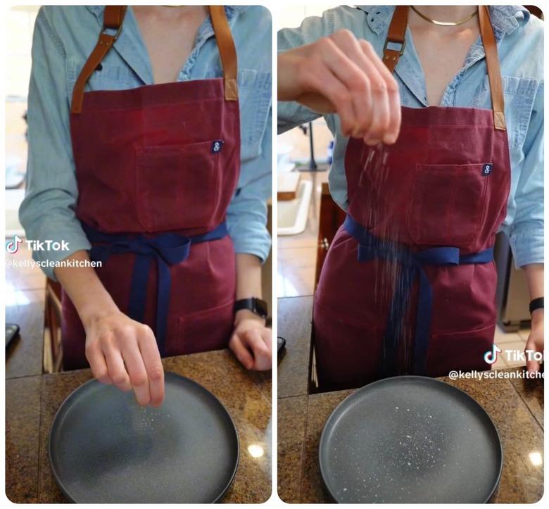 Person in apron salting their food