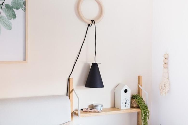 shelf with black hanging lamp and wall hanging nearby