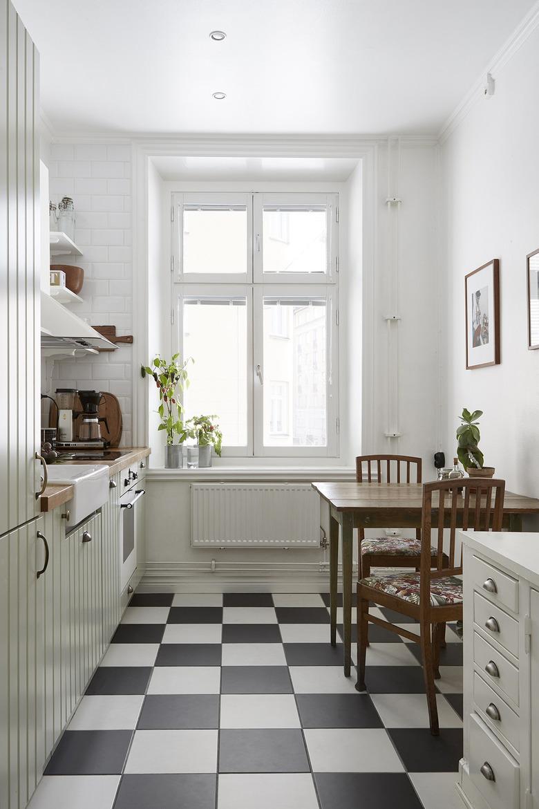 Scandinavian farmhouse kitchen with black and white checkerboard floor tile