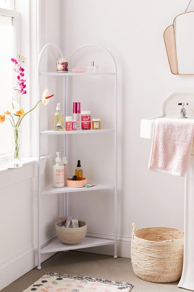 Shabby Chic Bathroom Storage in Corner bathroom shelf unit with lotions, basket, flowers, towel, sink, mirror.