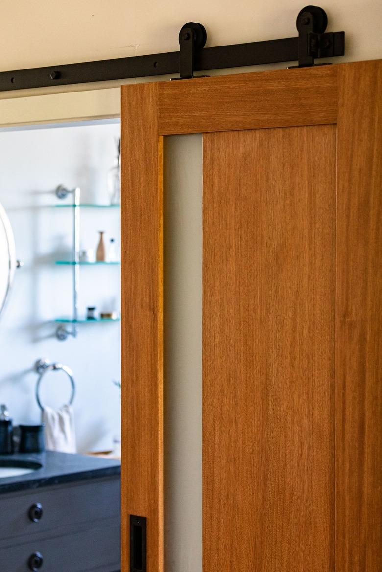 A wood door leading to a bathroom