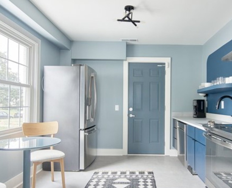 Blue kitchen with stainless refrigerator, stove.