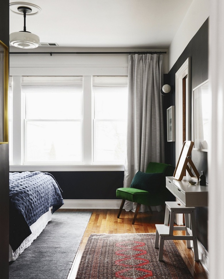 small bedroom with vintage rug and green velvet chair