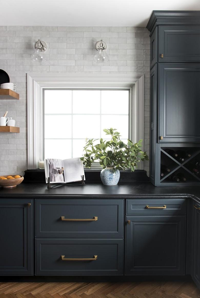 dark blue kitchen cabinets with black soapstone countertop