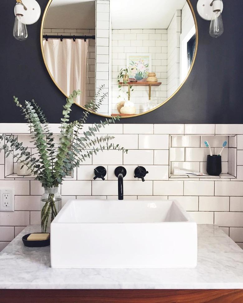 bathroom backsplash idea with white subway tile behind vessel sink on marble countertop