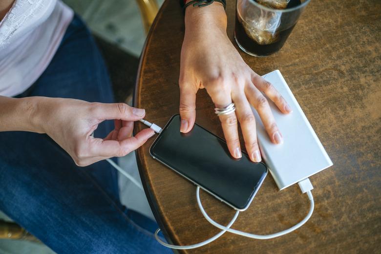 Close-up of Woman's hands plugging a mobile phone into a power bank