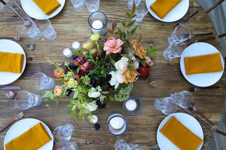 Floral centerpiece for Thanksgiving centerpieces on Tablescapes with white plates and ochre cloth napkins