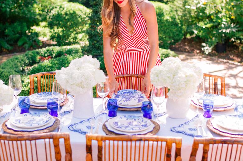 A table with white tablecloth and blue and white plates