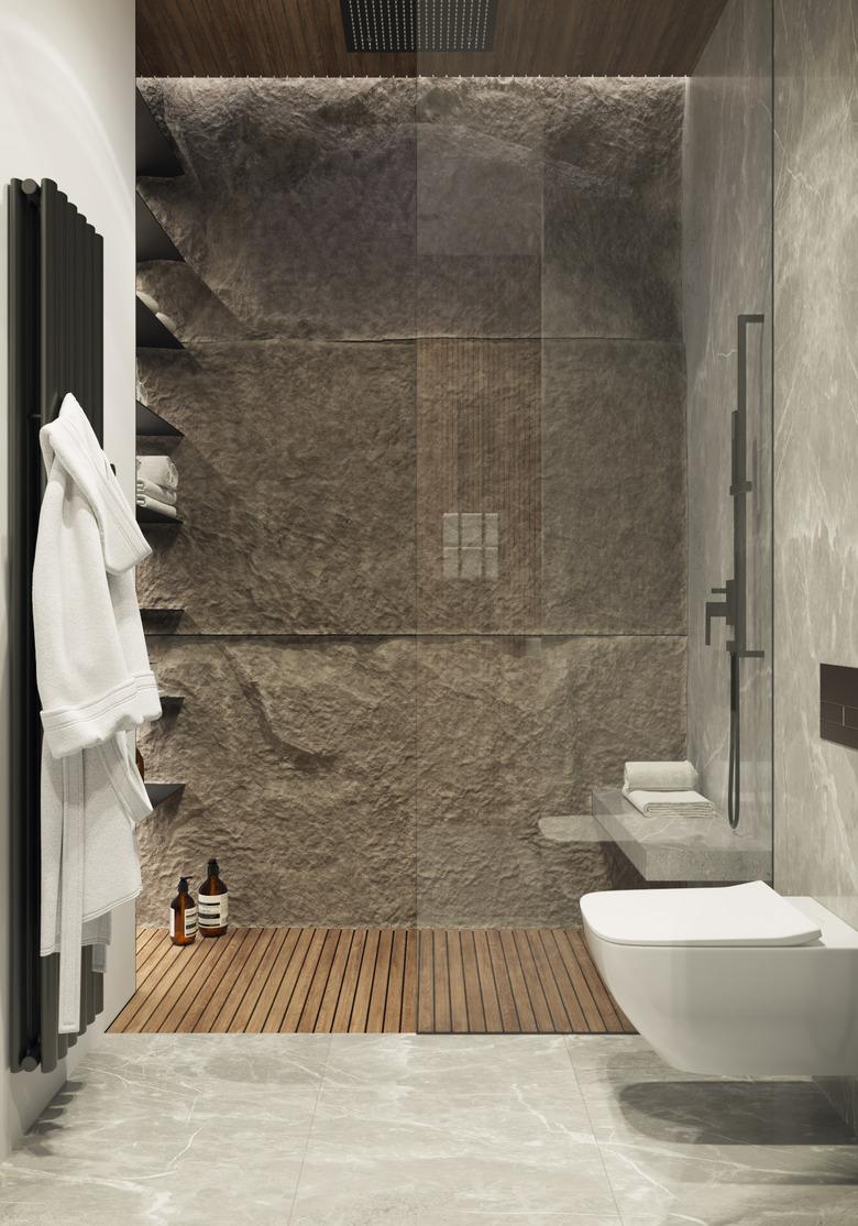 spa bathroom ideas with luxurious shower featuring stone wall and white fluffy bathrobes on a towel warmer