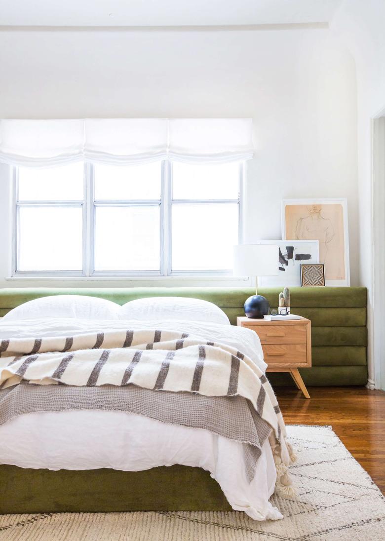 green channel tufted low-height headboard in white bedroom