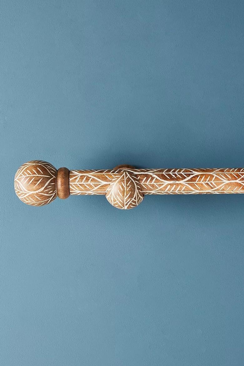 A twig-etched wooden curtain rod