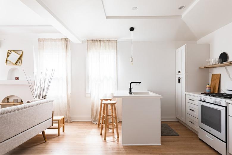 A white minimalist kitchen with an island sink