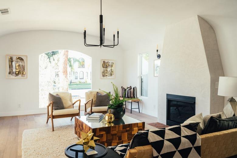 Living room with industrial chandelier and modernist seating and coffee table