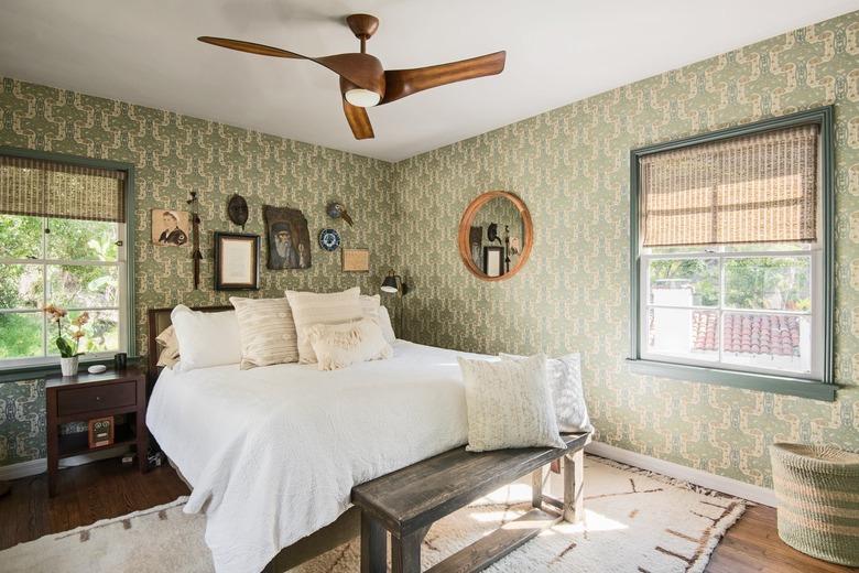 bedroom with white bedding and green wallpapered walls