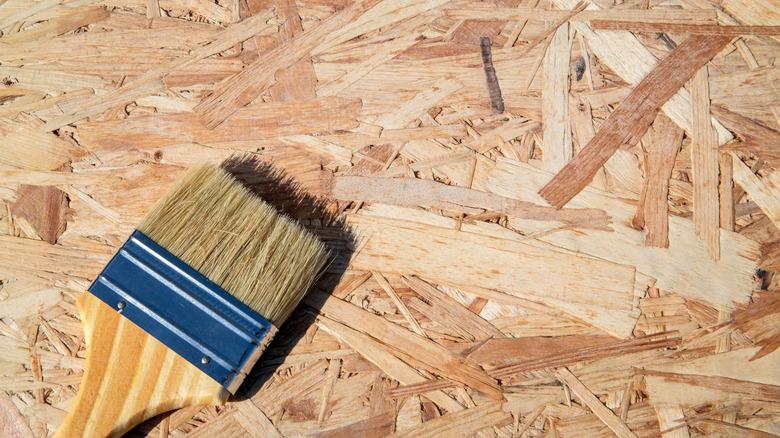 Paintbrush on chipboard, preparing for painting