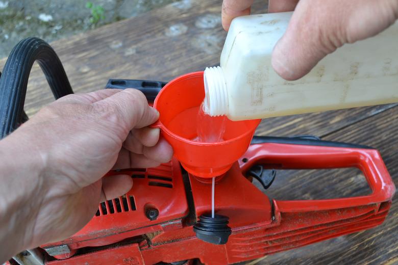 Refilling the red chainsaw.