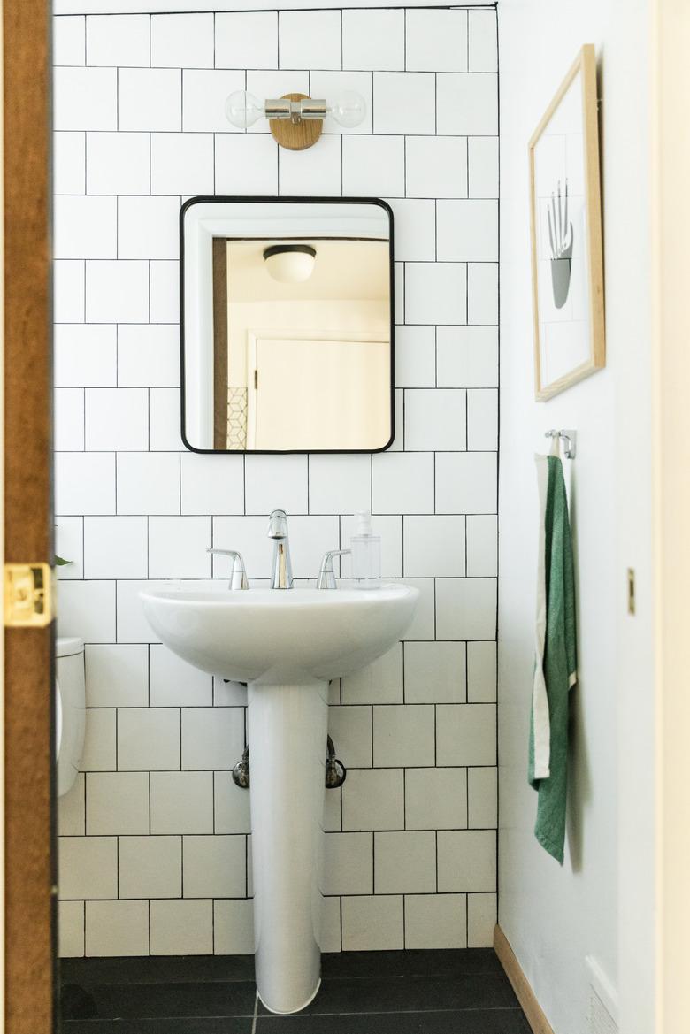 pedestal sink, subway tile backsplash and mirror