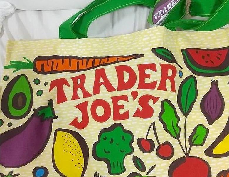 Trader Joe's reusable bag with fruits and veggie drawings on it like broccoli, lemon, eggplant, avocado, and cherries