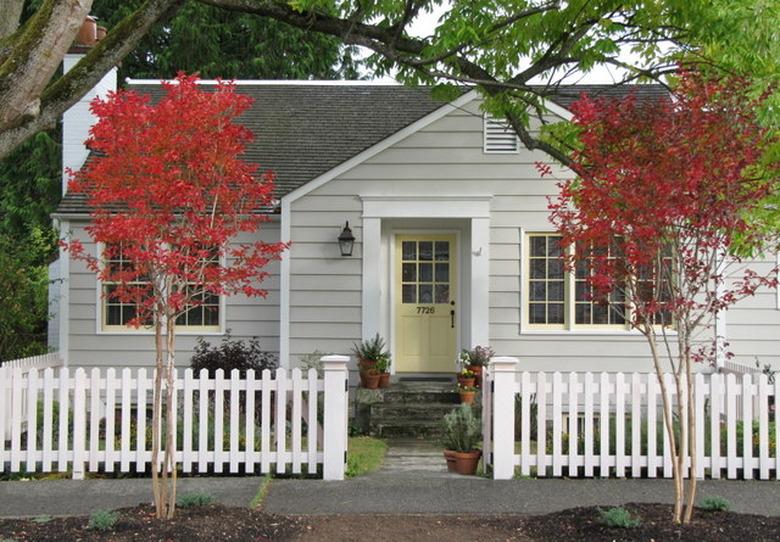 gray traditional home exterior with a white picket fence