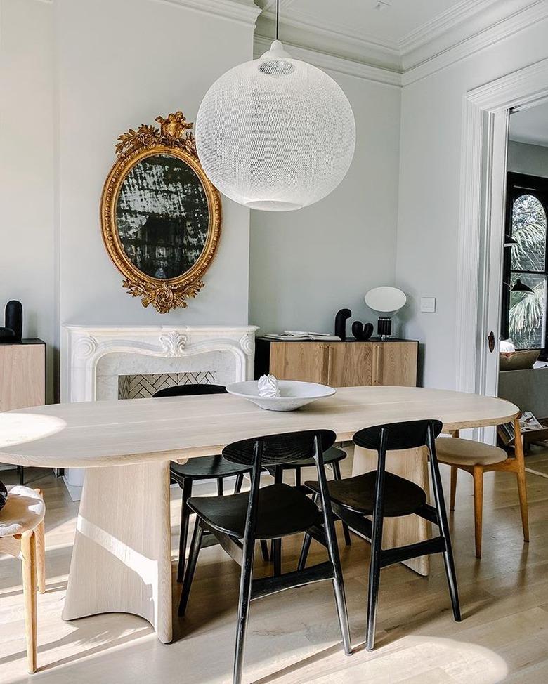 traditional mantel decor in dining room with white pendant light and ornate gold mirror