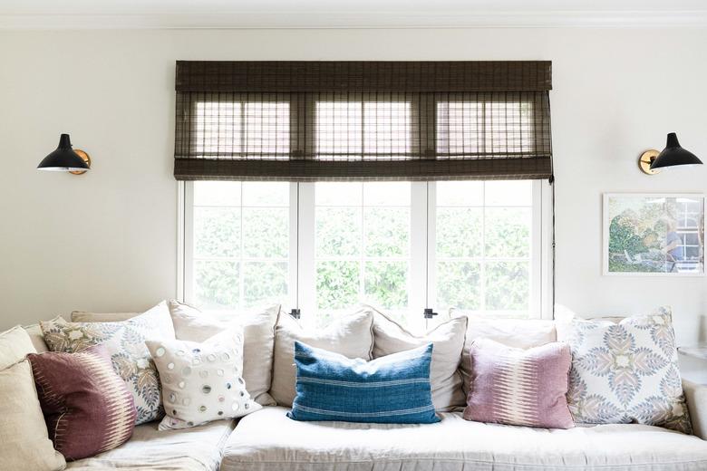 living room space with couch, pillows and two wall sconces