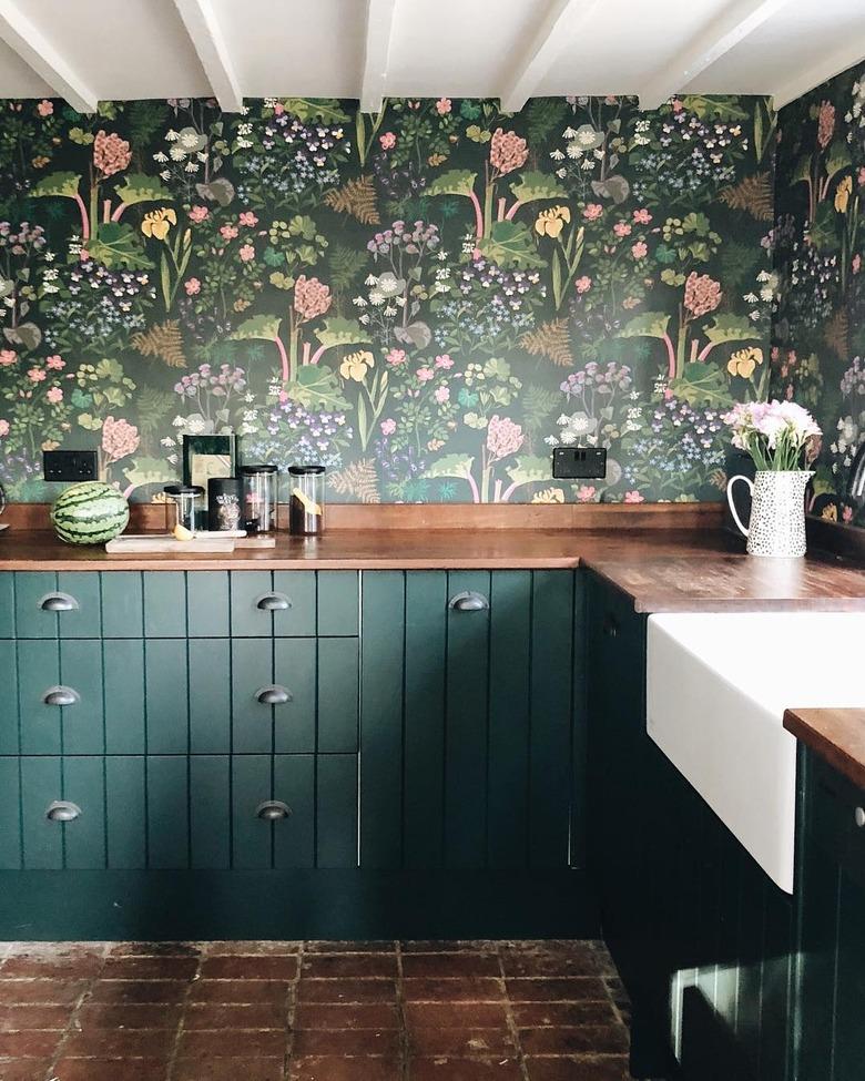 Kitchen wallpaper idea with green cabinets and floral print