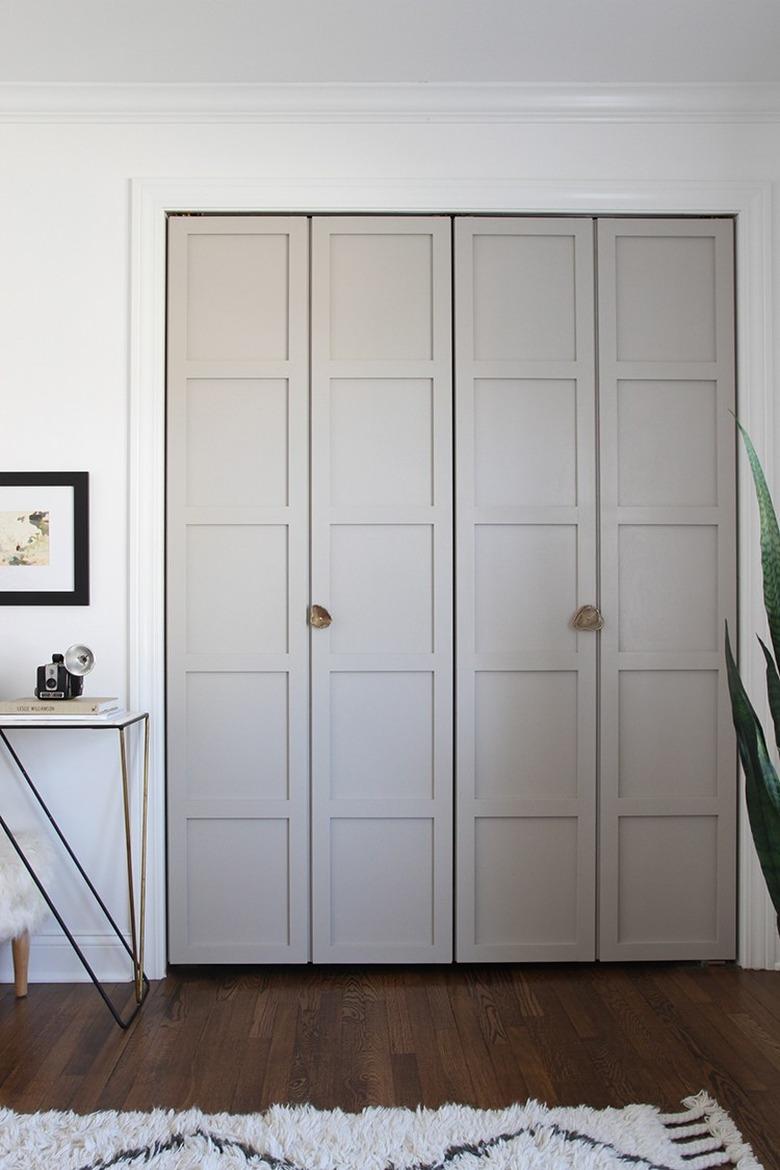 Bifold paneled closet doors with gold decorative handles