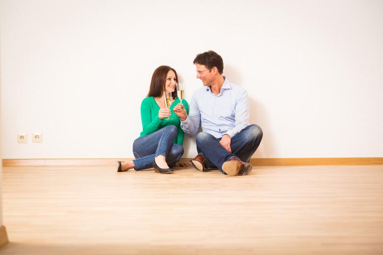 Couple sitting on hardwood floor.