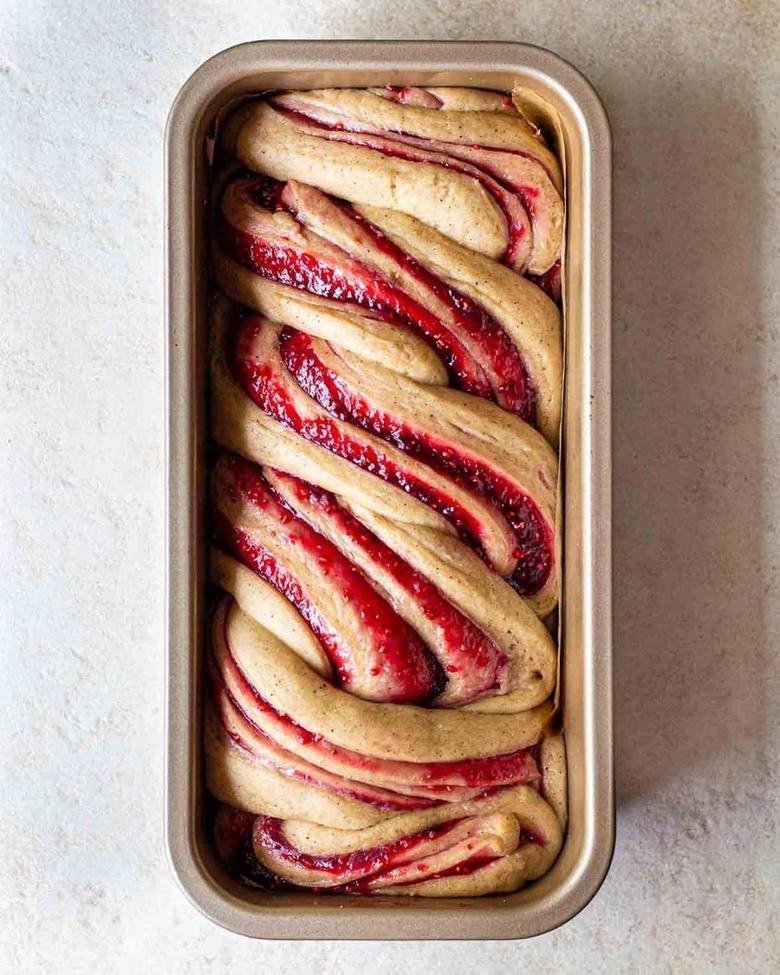 Vegan jam donut babka in a pan on a white table.