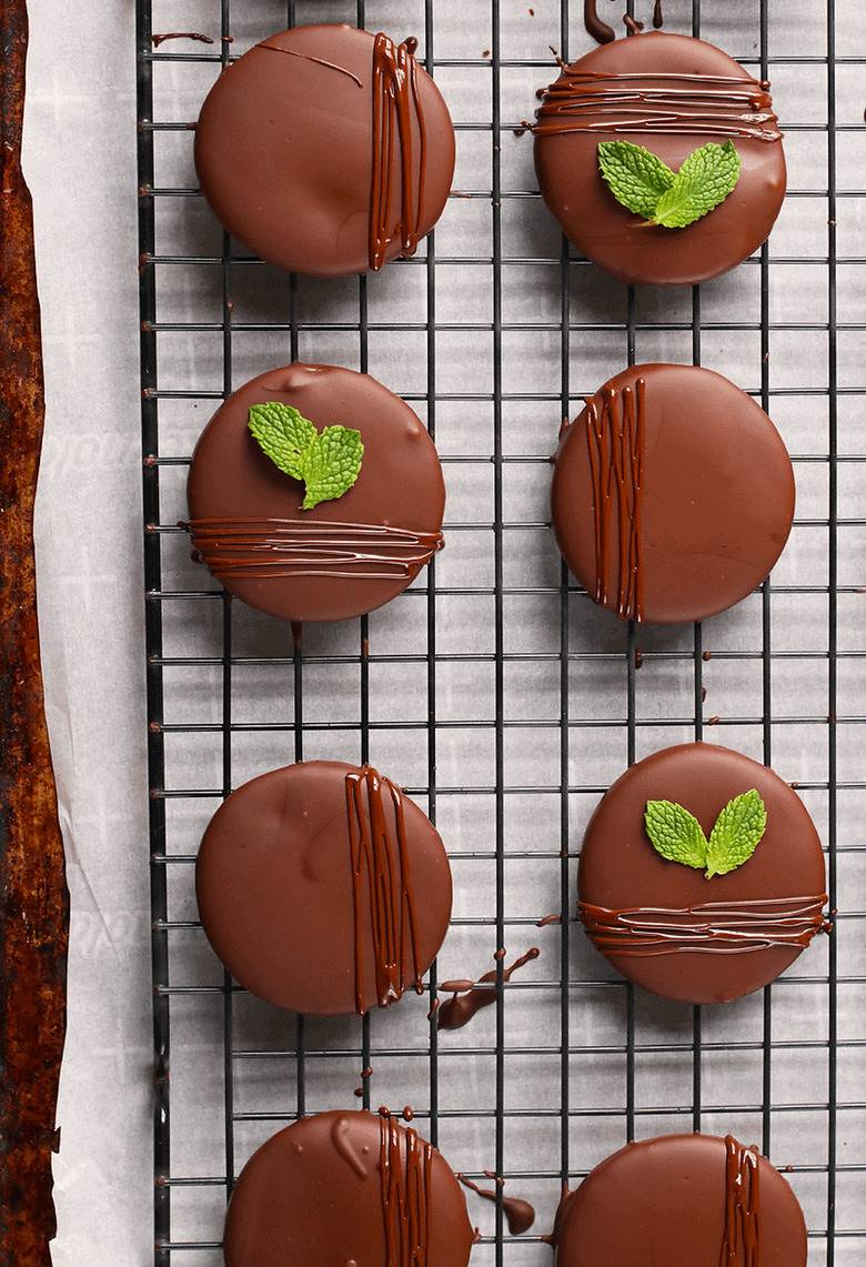 Chocolate-covered cookies with min leaves on a cooling tray