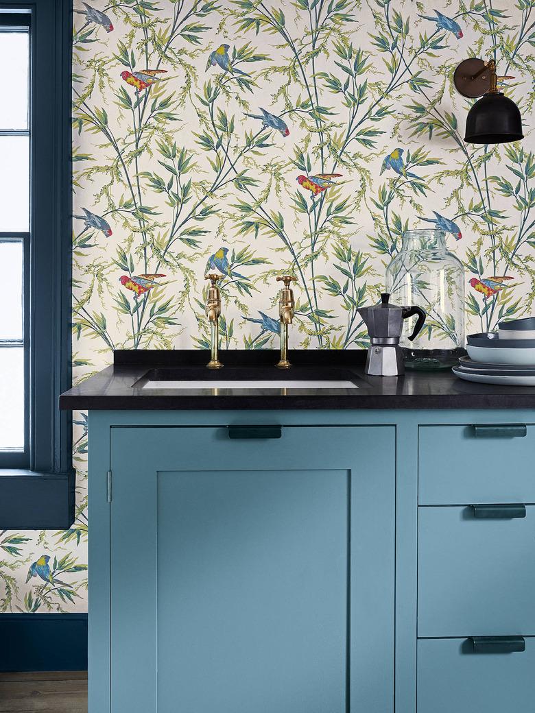 kitchen wallpaper backsplash idea with subtle botanical and bird pattern and blue cabinets