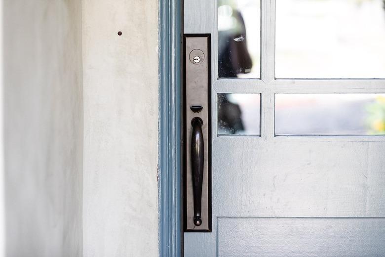 Close up of a blue door with black hardware