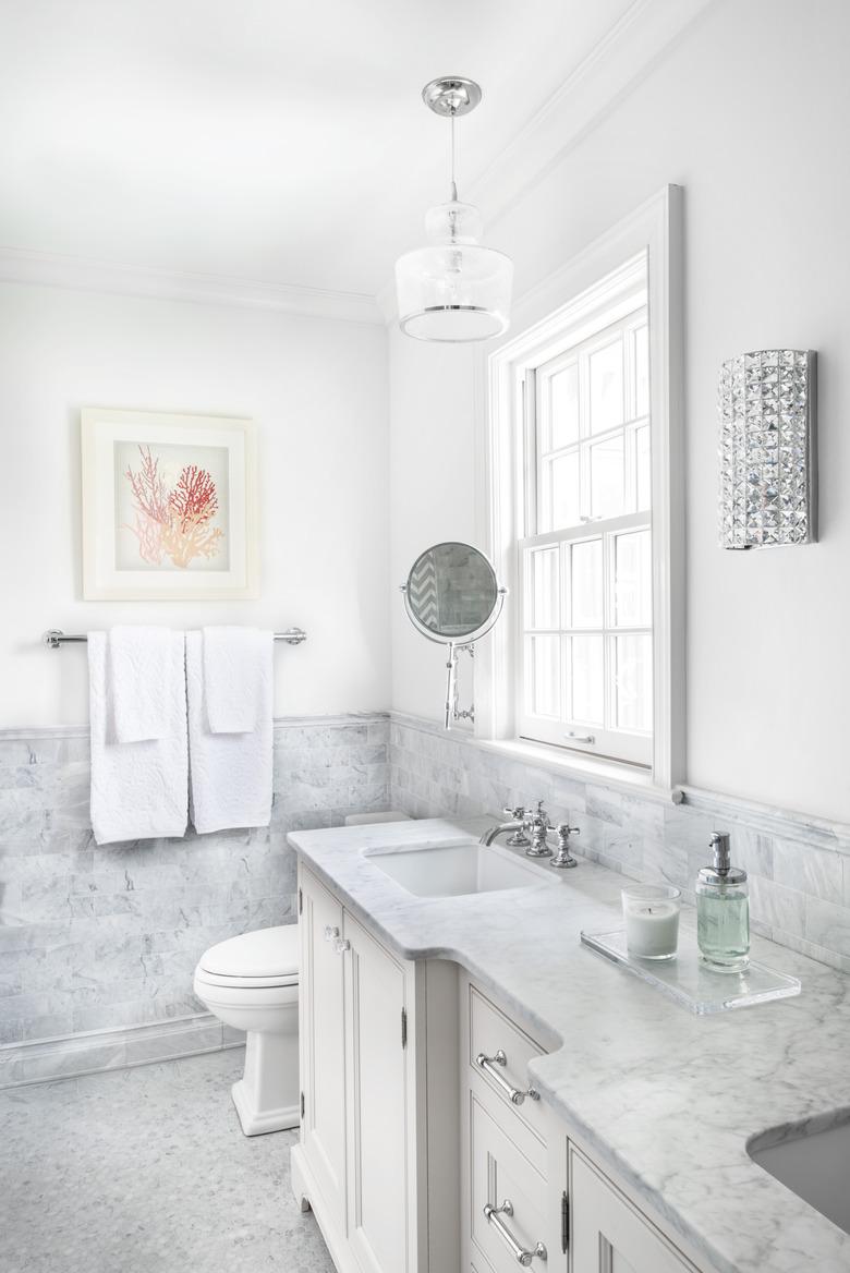 White bathroom with coastal theme and wainscoting