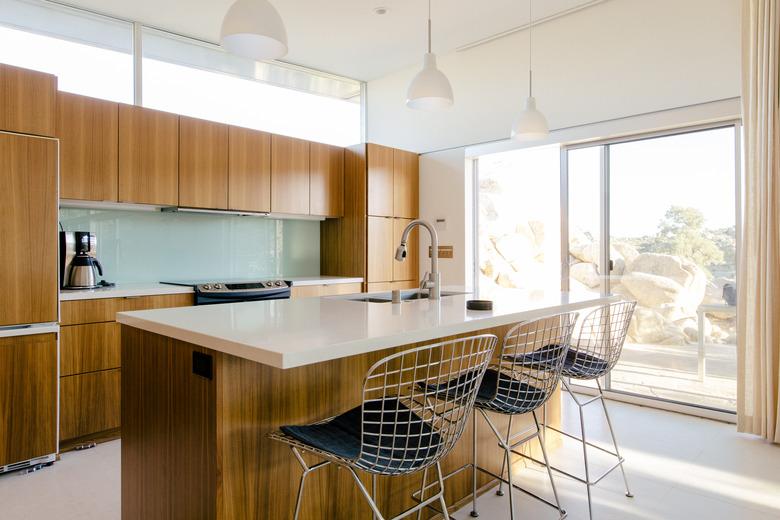 sunny kitchen with light countertop and wood cabinetry