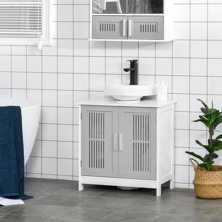 A white and gray vanity built underneath a pedestal sink