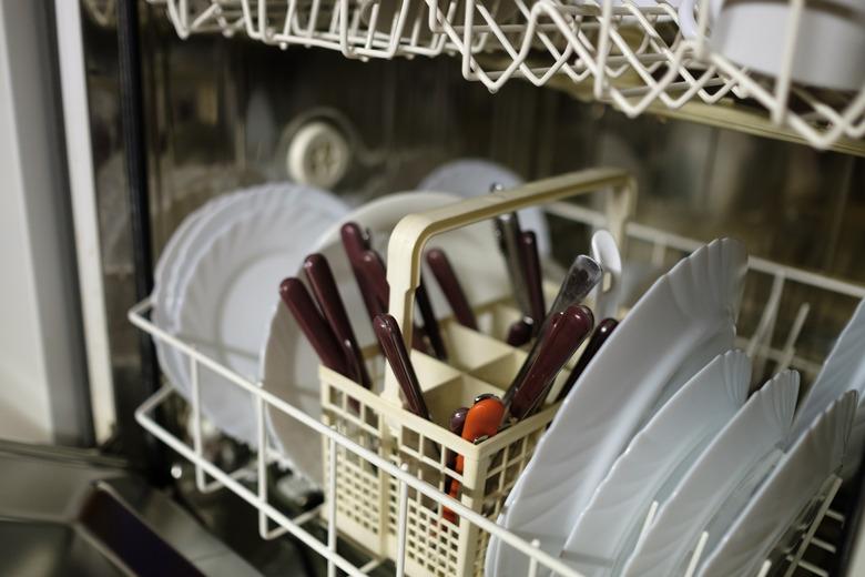 Dishwasher before cleaning process. Dirty plates ready to wash.