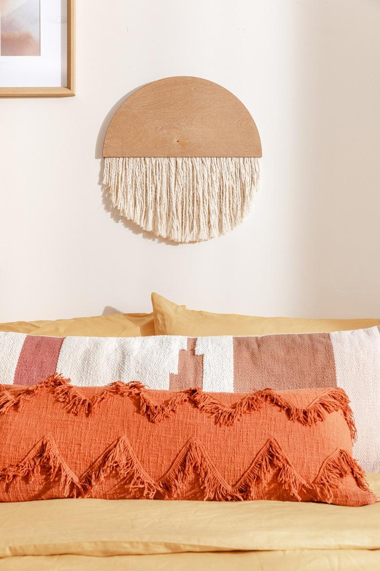 Beige painted bedroom with orange pillows and bedding