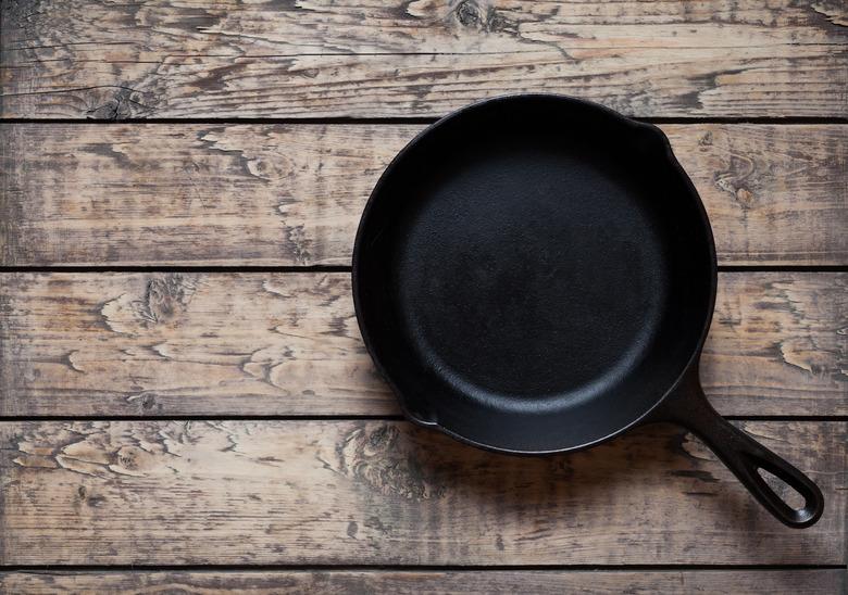 Traditional cast iron skillet pan on vintage wooden table