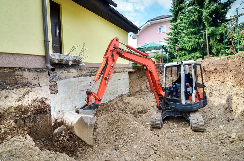 Family house being rebuilt with the help of an excavator.