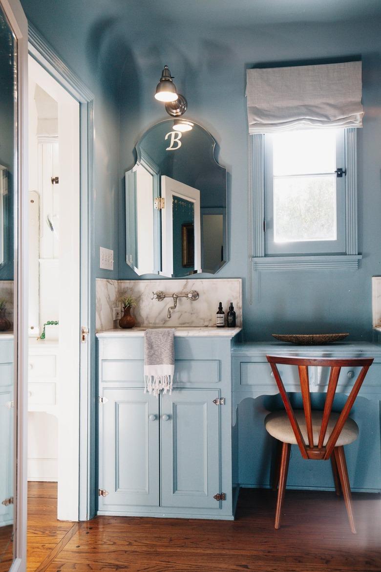 baby blue vanity area with art deco wood chair