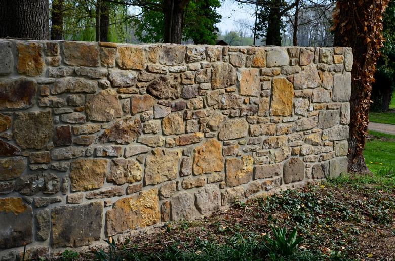 Old stone wall is being reconstructed between two plots. The stones are dismantled and remortared.