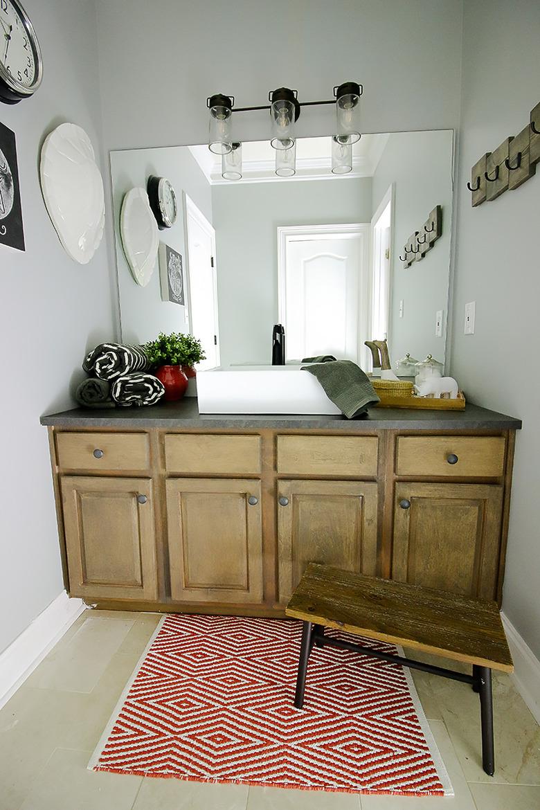 dark gray laminate bathroom countertop on rustic vanity cabinet in farmhouse bathroom