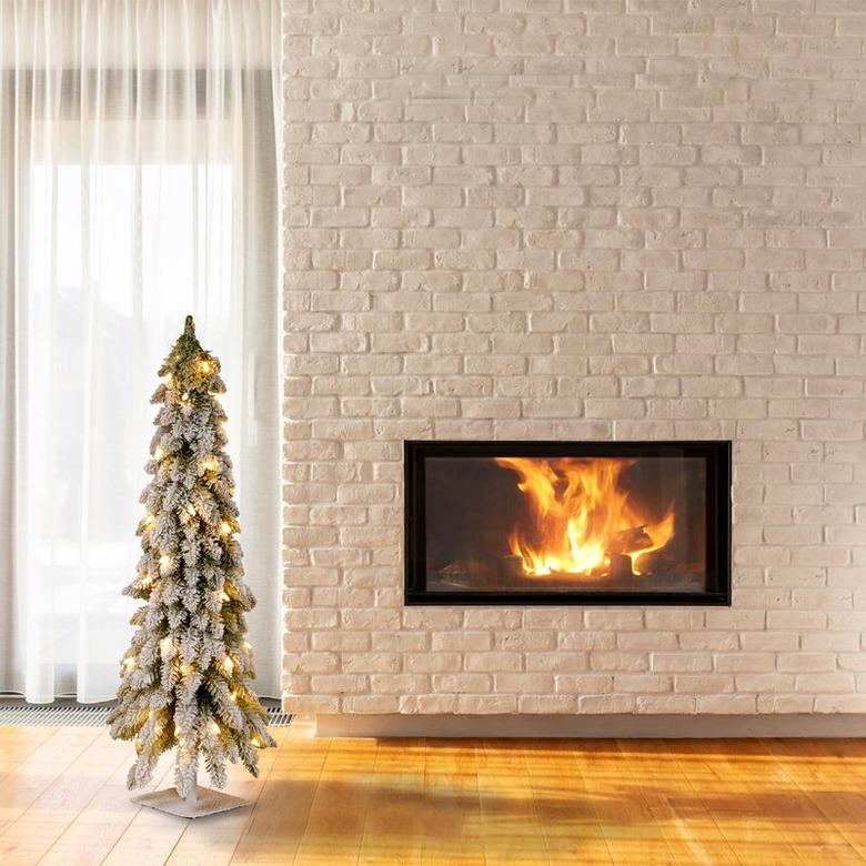 White Christmas Tree Ideas with Artificial white flocked Christmas tree with white brick fireplace.