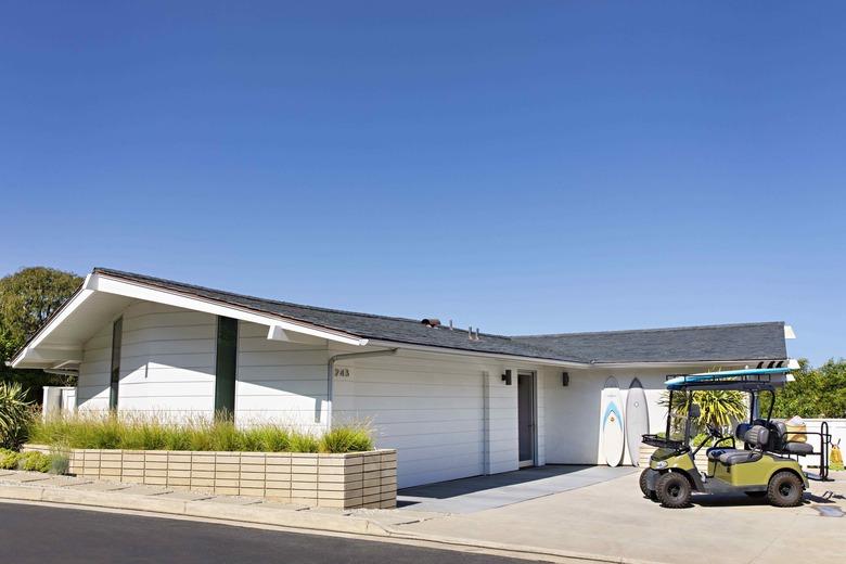 white garage door on ranch style home with golf cart out front