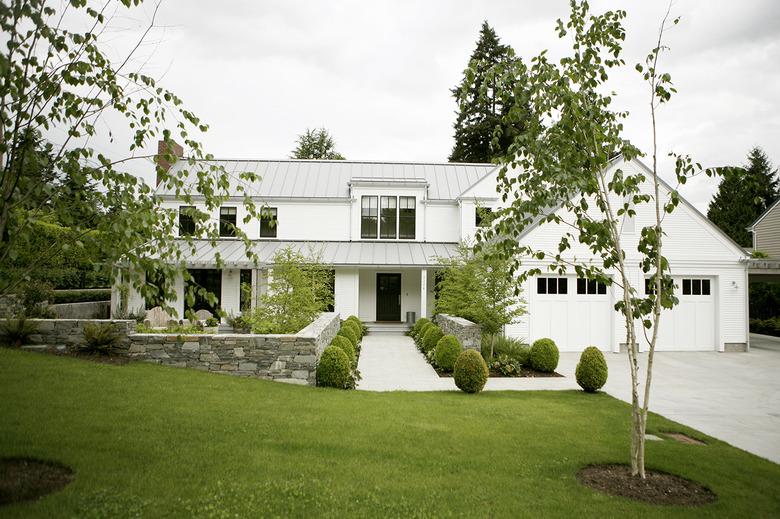 white garage door surrounded by greenery